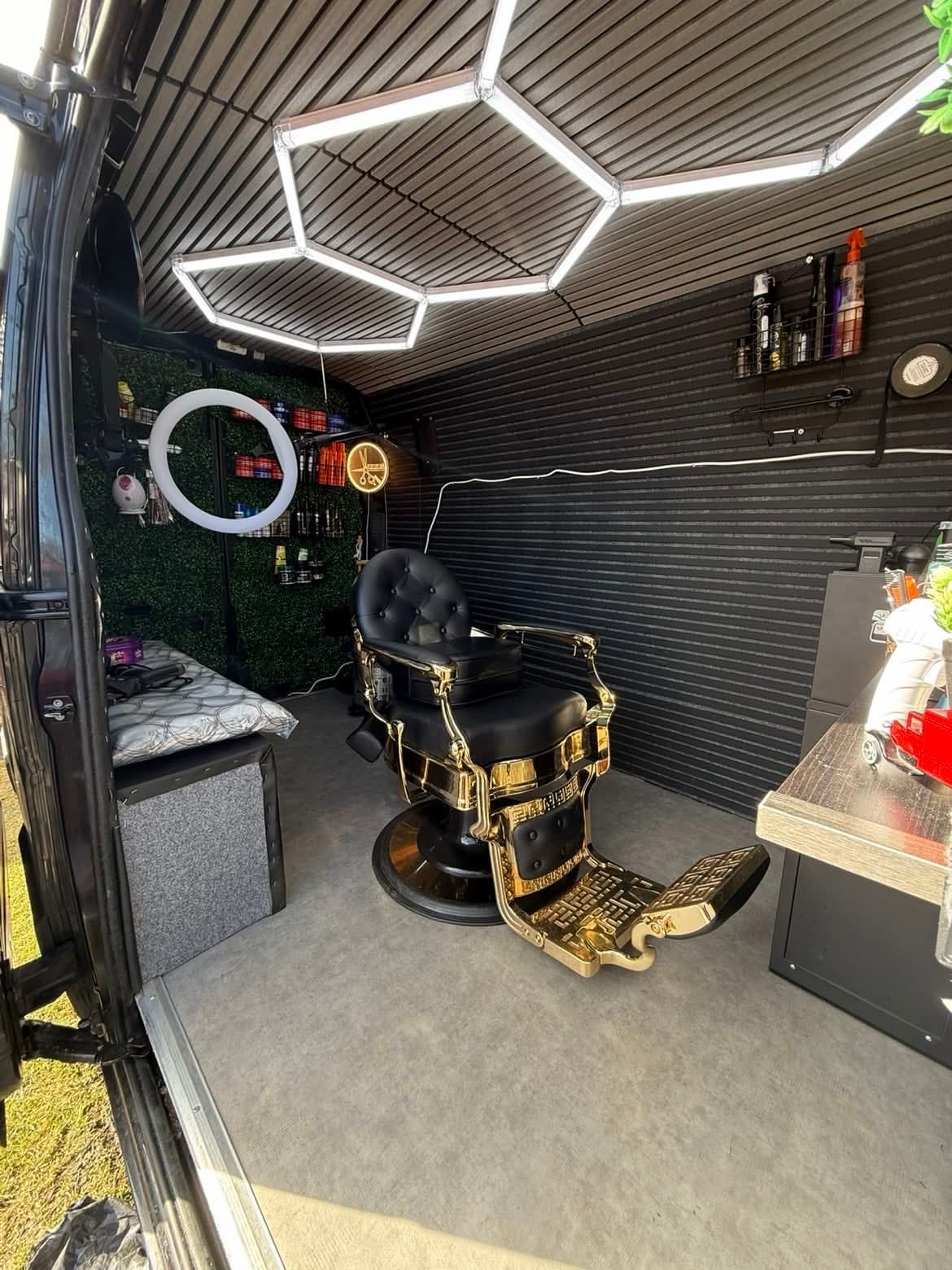 Interiören i barbershop-skåpbilen med guldstol och hexagonal LED-belysning